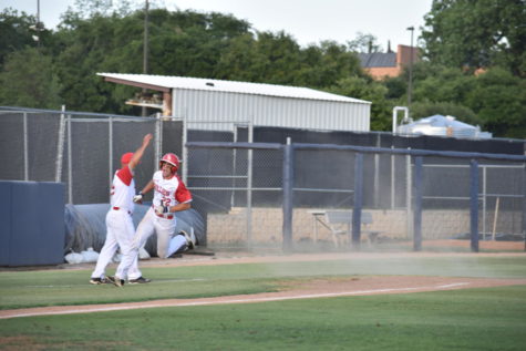 Coach Dietrich signals TJ Tomlinson to round third for the first score of the game.