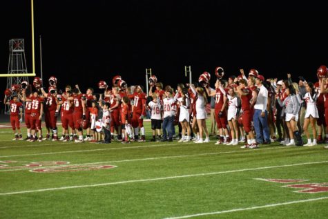 Billie football players, cheerleaders, and coaches sing the Alma Mater at the last home game.