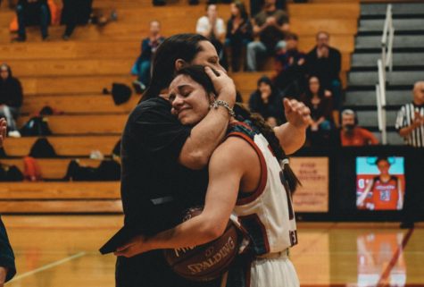 Mia Torres embraces her mother after being awarded her plaque and ball for 1500 career points.