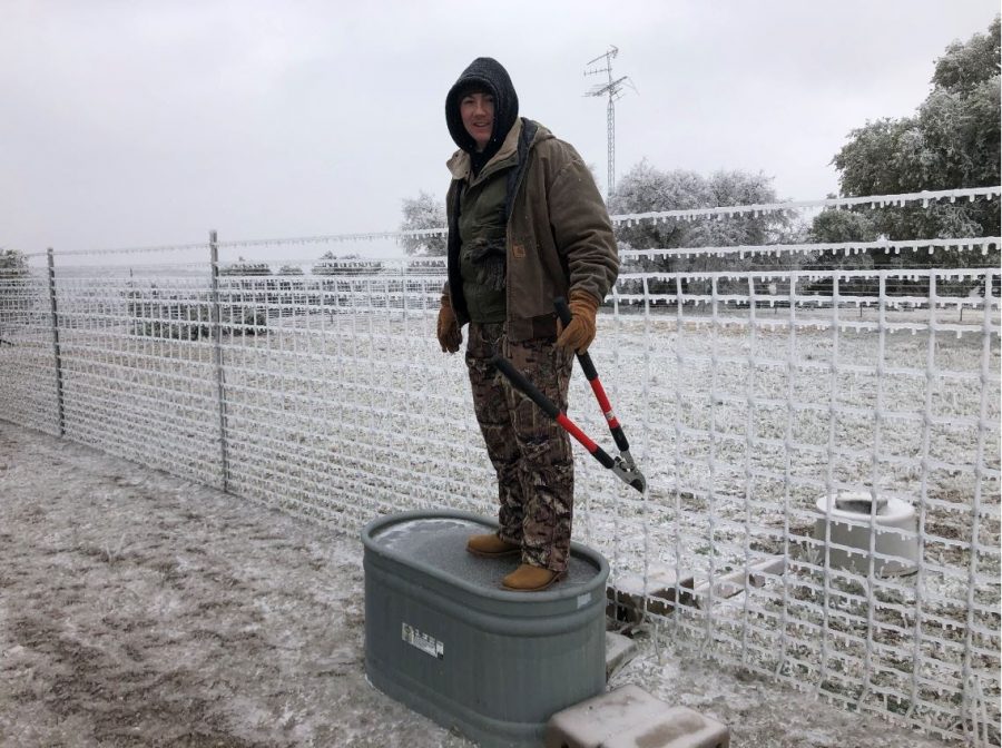 Everett Borton stands on a frozen water trough on his ranch.