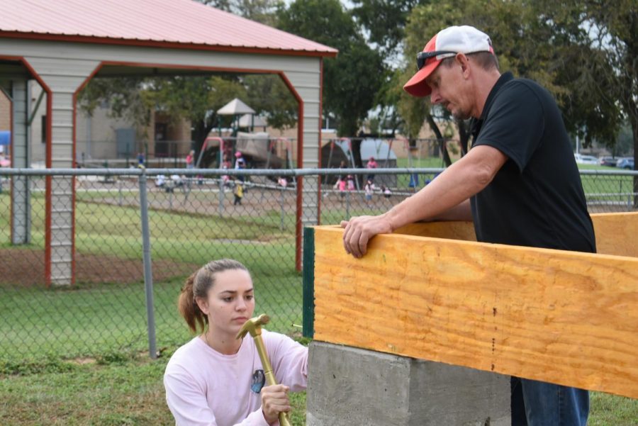 FHS construction student Minot Frantzen pounds a nail into the new tiny house construction project while her teacher, Mr. Joel Haby, hold the boards steady for her. Dedication of the bew project was held on Friday, Oct. 15.
