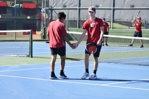 JV tennis players Nathan White and Isaac Sanchez celebrate a good shot in their doubles match.